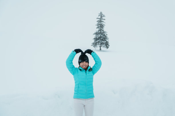 女游客在别北游玩，冬天穿毛衣的游客在雪地里观赏圣诞树。它是日本北海道的地标和著名景点。旅游度假概念图片下载