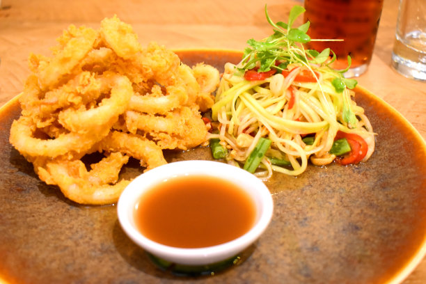 炸鱿鱼圈配上泰式辣木瓜沙拉和甜酱。图片下载