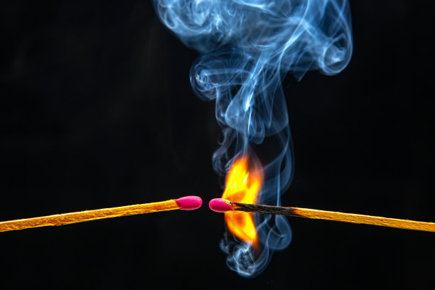 火和烟。黑色背景上燃烧着冒烟的火柴。来自火焰的热和光图片下载