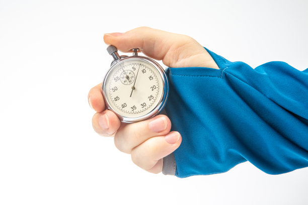 手与机械模拟秒表在白色背景。时件精度。测量速度间隔图片下载