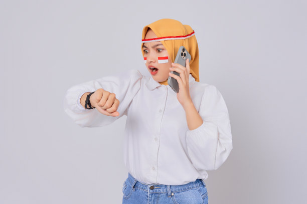 戴着头巾的年轻亚洲穆斯林妇女在白色背景下打电话，看起来很孤独。8月17日庆祝印尼独立日图片下载