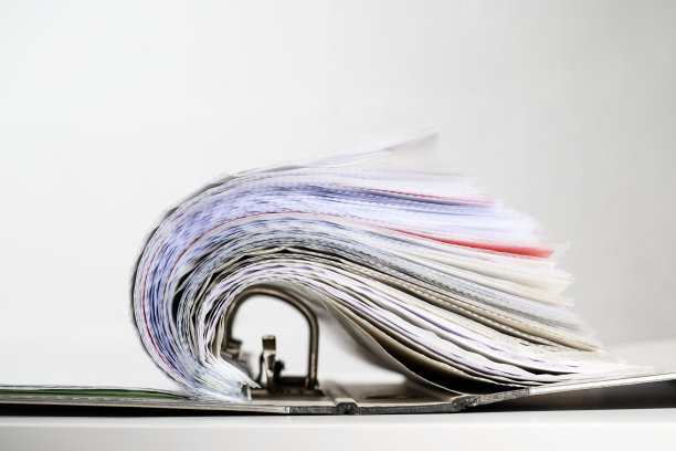 环形活页夹内装有许多文件，装在透明的套筒或打孔的口袋里，打开后呈波浪状，办公、组织和经营理念、复印空间，精选重点图片下载