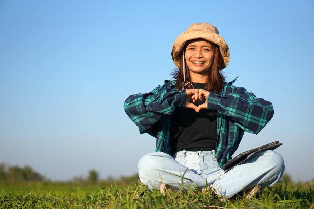 亚洲女农民使用电脑分析水稻生长情况。图片下载