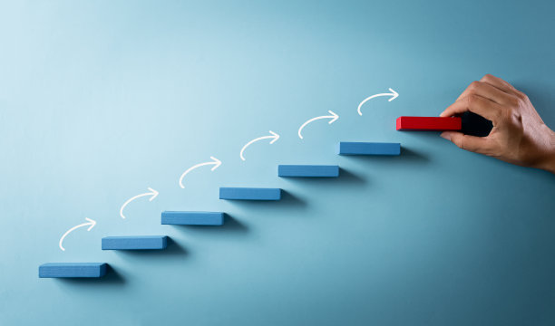 建立成功基础的概念。手持木块堆叠成阶梯，在柔和的背景下成功的商业成长理念。图片下载