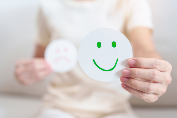 女性展示快乐笑脸纸，心理健康评估，心理学，健康养生，反馈，顾客评论，体验，满意度调查，积极思考和世界心理卫生日图片下载