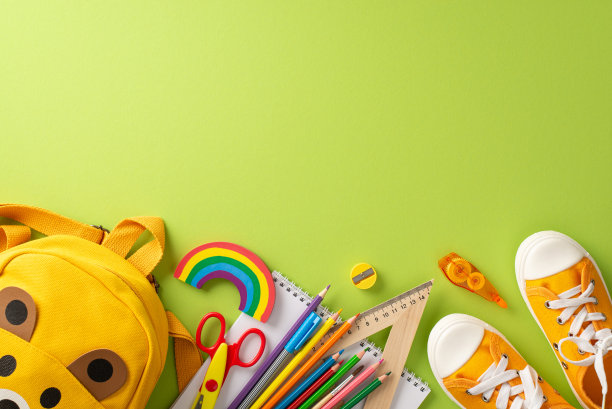 通过俯视图，激发家长和教育工作者的兴趣，在浅绿色孤立的背景下，展示一个黄色帆布背包，里面有一系列彩色的学习用品，用于教育活动图片下载