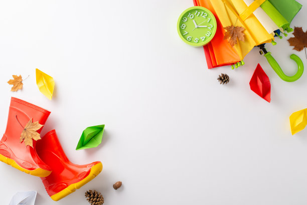 孩子们的秋雨探险。自上而下的图像，在白色孤立的背景上，有一把彩色雨伞和红色橡胶靴，有文字或广告的空间图片下载