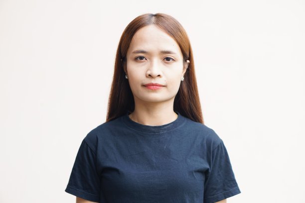 亚洲女人开心地笑着灰色的墙背景。图片下载