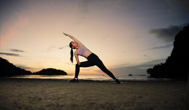 在泰国甲米的莱莱海滩上做瑜伽的女人，海滩上的户外瑜伽运动，健康的生活方式图片下载