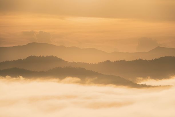 太阳透过云层照耀在这个地区的山上图片下载