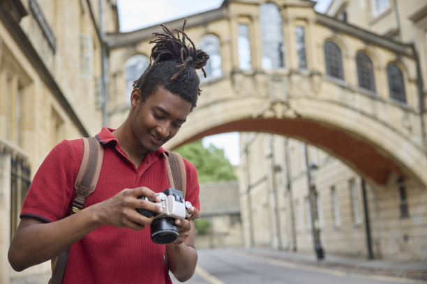 年轻人在牛津旅游时用相机拍照图片下载