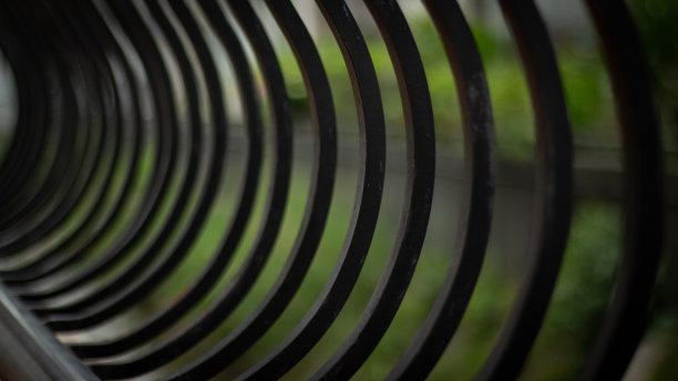 在宁静的花园里，一道醒目的黑色铁栅栏优雅地矗立着，为宁静的景观增添了一丝精致图片下载