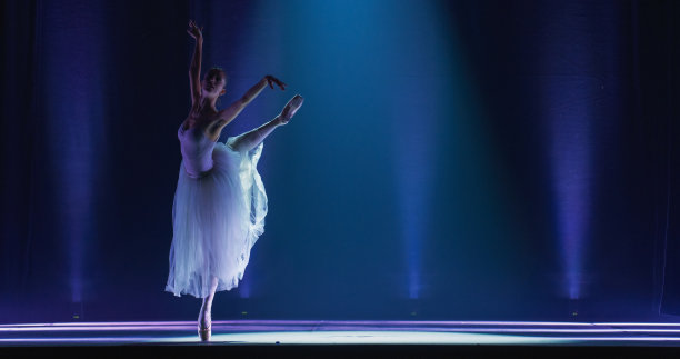 芭蕾舞女演员穿着尖头鞋和白色芭蕾舞裙在经典戏剧舞台上跳舞和排练的电影镜头。优雅的古典芭蕾舞女舞者正在表演舞蹈图片下载