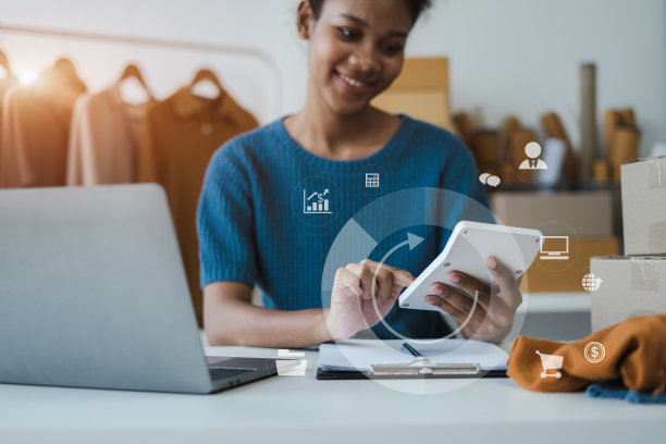 在家工作的女企业家对网上业务的看法。女企业主使用计算器和笔记本电脑在家办公。图片下载