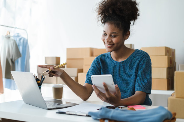 创业者手里拿着计算器，在家办公计算财务费用，网上市场包装盒配送，创业成功的小企业主，中小企业，概念。图片下载