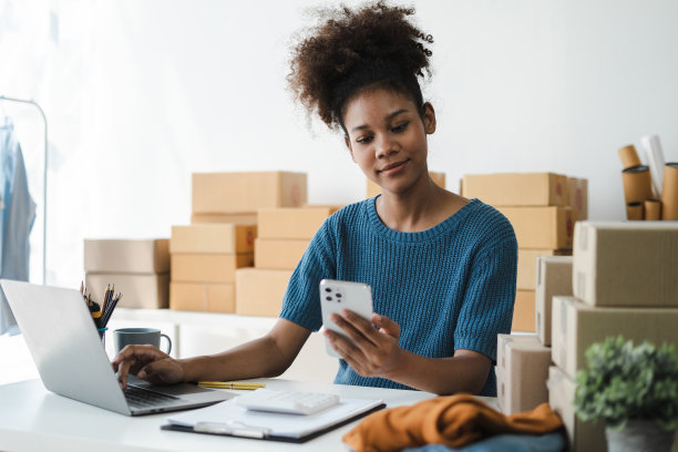 拿着智能手机的女人。在家工作的企业家。网上购物，电子商务，网上银行，消费，在家工作的概念。图片下载