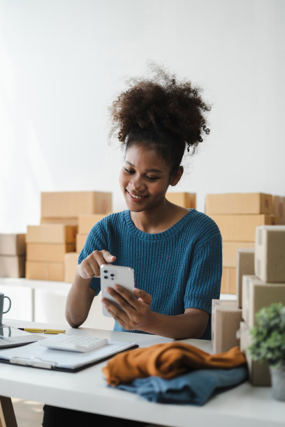 拿着智能手机的女人。在家工作的企业家。网上购物，电子商务，网上银行，消费，在家工作的概念。图片下载