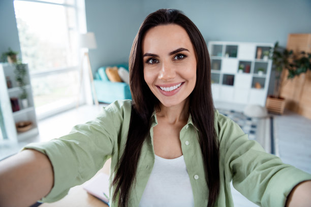 可爱开朗的人咧着嘴笑的照片使自拍录影在宽敞的现代商务中心内图片下载
