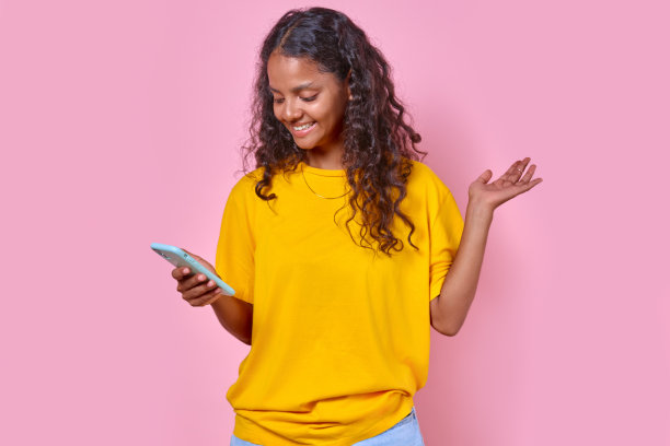 年轻快乐的印度少女在演播室站在电话上打视频电话图片下载