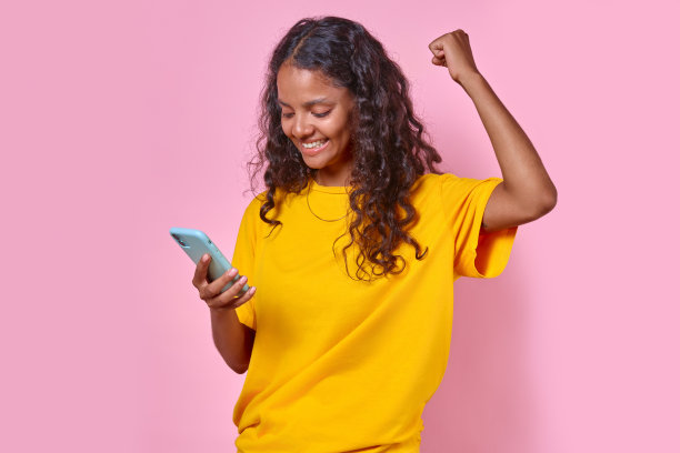 年轻、开朗、有魅力的印度少女拿着手机站在演播室里图片下载