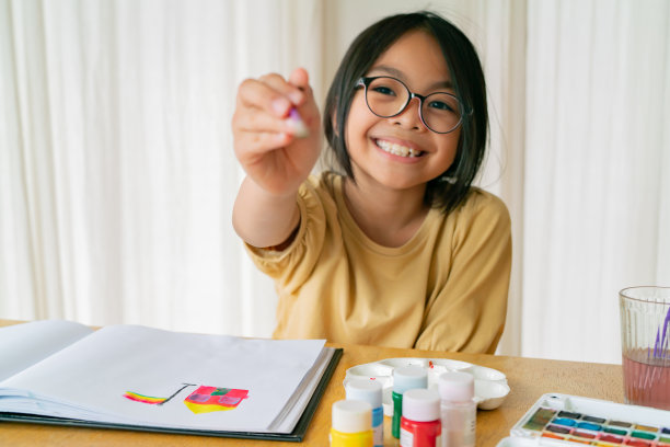 年轻的亚洲女孩坐在家里画水彩画，以发展能力和改善心理健康。灵感迸发的女艺术家。图片下载