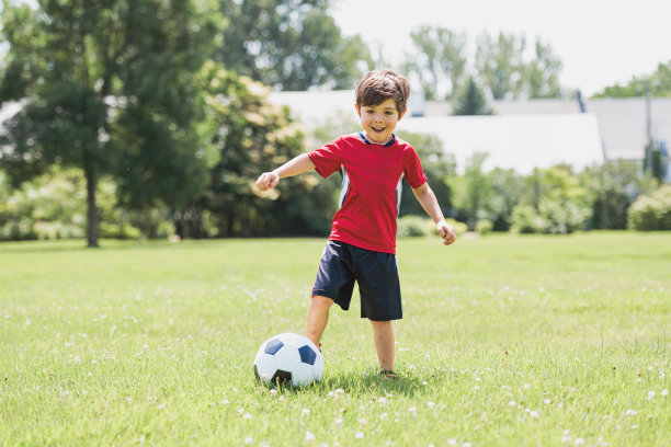 年轻的足球运动员在球场上玩球图片下载