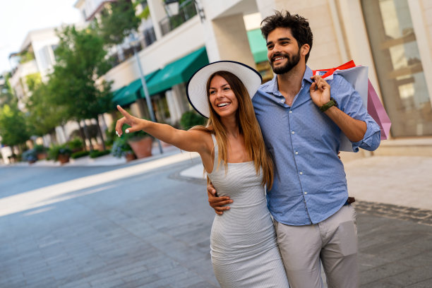 兴奋的人们开心地购物。一对年轻夫妇享受暑假的户外照片图片下载