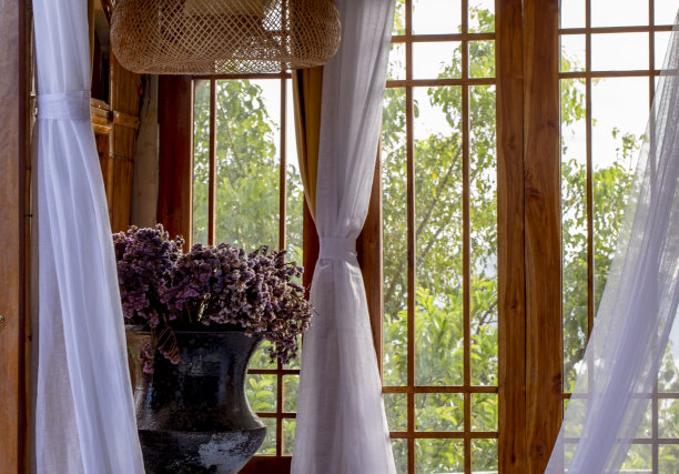 木窗，白色窗帘，角落里放着一瓶干花。图片下载