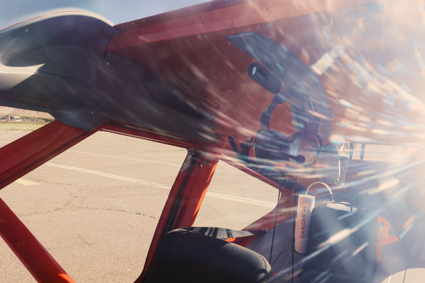 驾驶员的耳机在驾驶舱里。在背景中，一个男人仰望天空图片下载