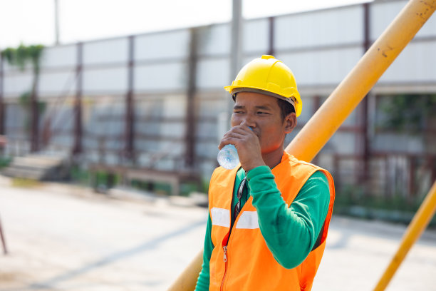 建筑工人让人们从水瓶里喝水。从辛苦的工作中休息一下。累了热了擦汗图片下载