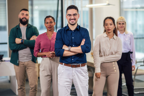 一群成功的商业人士在现代办公室里看着镜头的肖像。图片下载