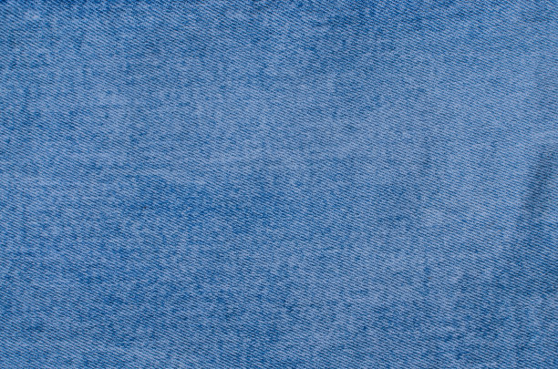 特写牛仔布的纹理细节，突出独特的线条和编织。一个完美的形象，代表当代的时尚，风格和趋势。图片下载