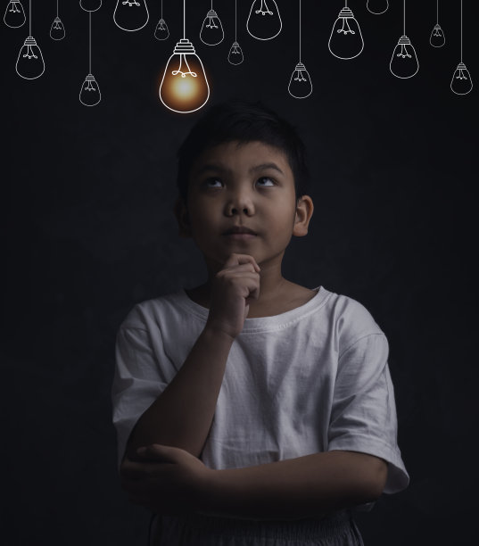 在灰色的墙壁背景上，思考的男孩用头顶上的小灯泡仰望教育理念和智能解决问题。图片下载