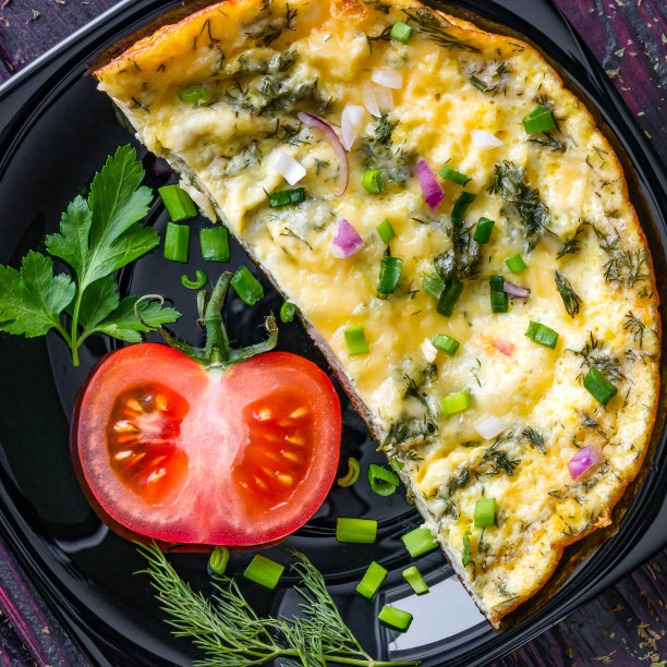 黑色盘子里有美味的煎蛋卷图片下载