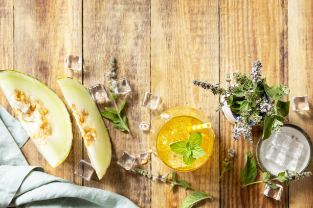 清新爽口的夏季果香饮料，时令饮料。在质朴的木桌上，一杯柠檬甜瓜汁，加冰块和薄荷。从上面看。副本的空间。图片下载