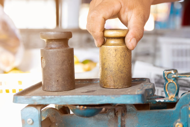 用手把重量放在铁秤上。图片下载