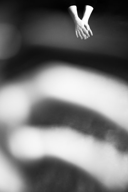 一名舞者优雅优雅的双手，舞动着身体部位，黑白肖像的表演者的双手在黑暗的背景上图片下载