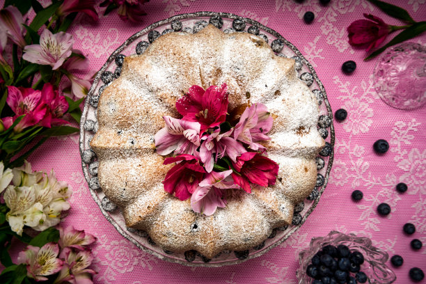 用糖粉和鲜花装饰的柠檬蓝莓蛋糕的顶部视图图片下载