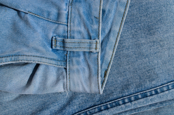 牛仔裤接缝的特写，展示了为服装增添风格和个性的对比线条。完美的时尚和服装项目。图片下载