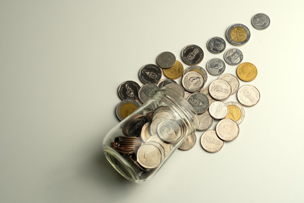 硬币装在一个白色背景的小罐子里图片下载