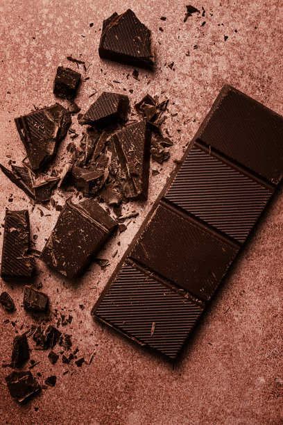 巧克力棒，用于制作糖果，破碎，粉碎，棕色背景，俯视图，图片下载
