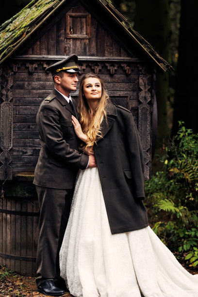 新婚夫妇在秋天的公园水井旁。身着军装的新郎图片下载