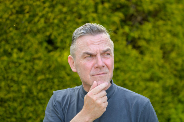 一个花白头发的中年男子站在花园里的画像图片下载