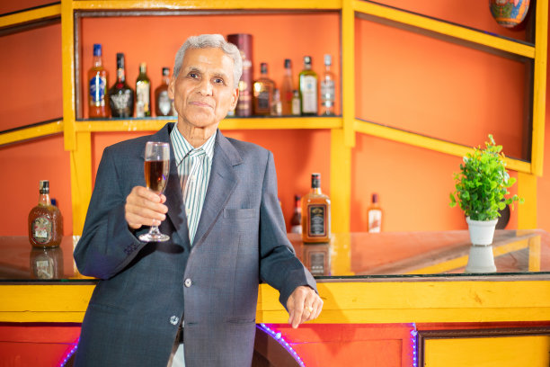 快乐成功的印度高级商人手里拿着一杯酒，老企业男性，退休生活图片下载