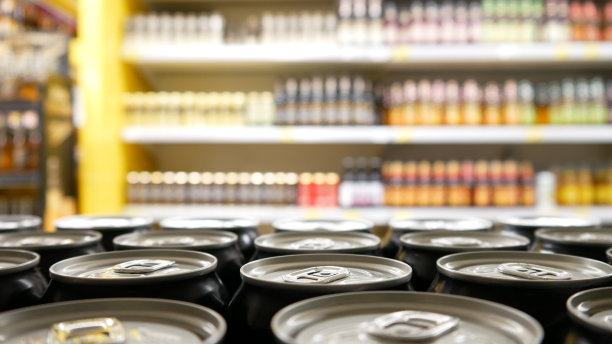 商店货架上许多黑色啤酒罐的特写镜头图片下载