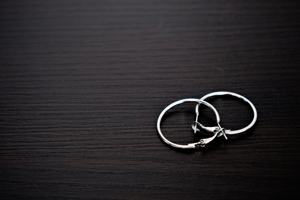 黑色背景上的银耳环。有文字的空间。特写镜头图片下载