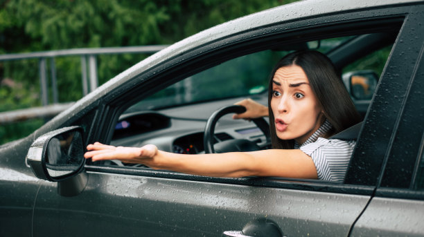 交通堵塞。激进的驾驶员。车祸。特写照片:不高兴的愤怒的女人开着车，对着别人大喊大叫，双手高举在空中。人类的消极表达图片下载