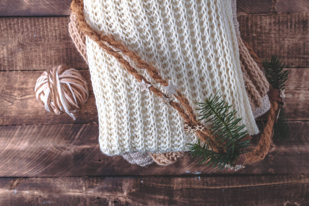 温暖，柔和的衣服，针织，色彩柔和的围巾和一个球针织纱线在木制背景。冬天、秋天的衣服图片下载