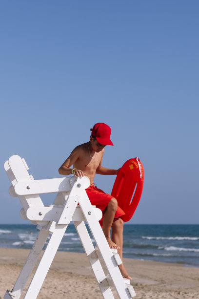 海滩上瞭望塔旁边的救生员图片下载