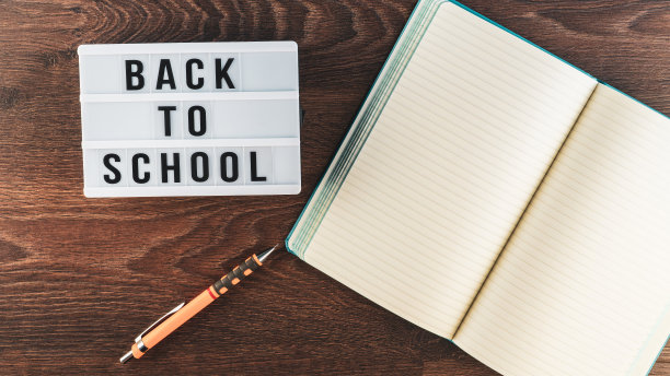 回到学校的概念。木制背景的学习用品。回到学校的白色白板上的字母。文本的复制空间。包括选择性焦点图片下载